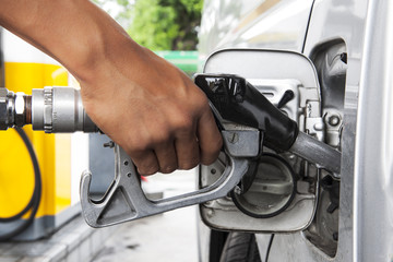 Car at gas station being filled with fuel.