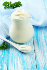 Sour cream in pitcher on table close-up