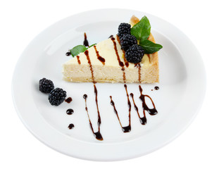 Slice of cheesecake with chocolate sauce and blackberry