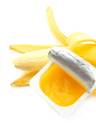 Tasty dessert in open plastic cup and banana, isolated on white