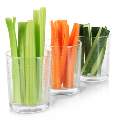 Fresh green celery with vegetables in glasses isolated on white
