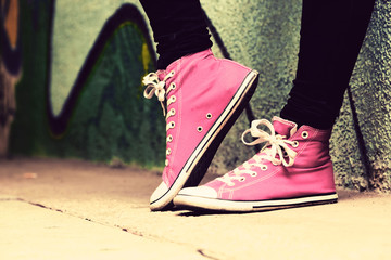 Close up of pink sneakers worn by a teenager.