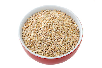 pearl barley in red bowl on red background
