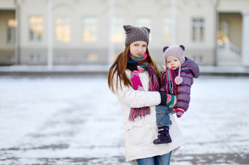 Young mother and her daughter at winter day