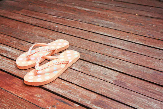 Colorful flip flop sandals on wood background
