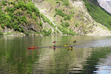 Fototapeta na wymiar Group of people in kayaks floating in the Sognefjord