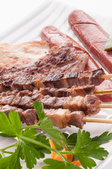 Grilled meat on white dish, close-up
