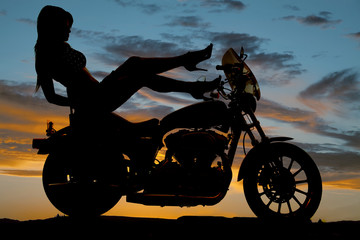 Obraz na płótnie Canvas silhouette woman motorcycle heels up hand down