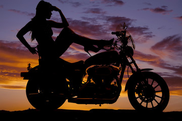 Obraz na płótnie Canvas silhouette woman motorcycle heels up hand head