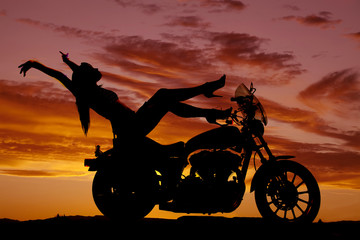 Obraz na płótnie Canvas silhouette woman motorcycle heels up hands back