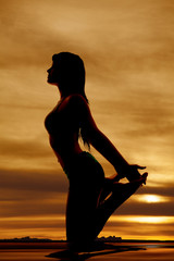 silhouette woman side hands on feet