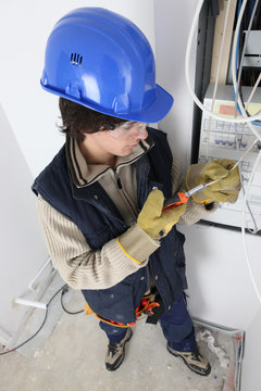 Young man repairing a distribution board