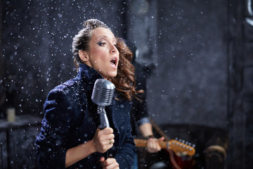 Young female vocalist sings into microphone