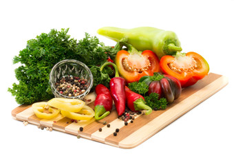 Mixture of peppers with greens on a wooden board