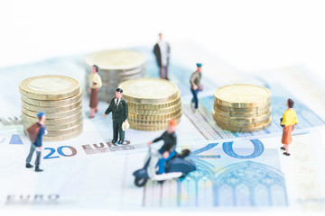 Obraz na płótnie Canvas Miniature people on 20 Euro banknotes and coins