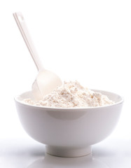 porcelain white bowl with spoon full of flour