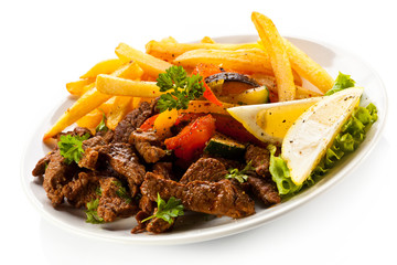Grilled meat with French fries and vegetables