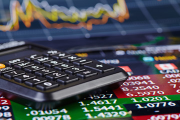 Calculator and financial chart as background. Selective focus