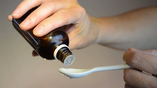 drop medicine on white spoon