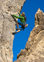 Fototapeta premium Climber dangles on the edge.