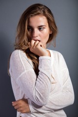 Pensive sexy woman in long sleeve white t-shirt on dark