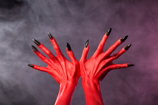 Red devil hands with sharp black nails, extreme body-art