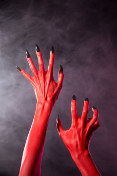 Red devil hands with black nails, extreme body-art