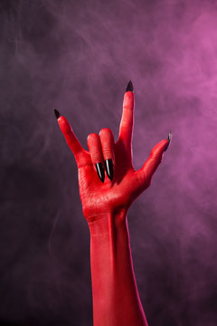 Rock sign, red devil hand with black nails