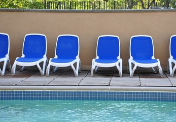 Obraz na płótnie Canvas Blue and white chairs near the pool