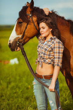 beautiful woman standing near a horse
