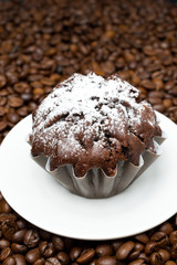 chocolate muffin on a background of coffee beans, close-up