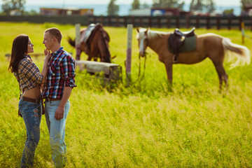 couple standing on farm with horses