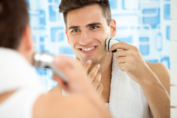 man shaving with electric shaver