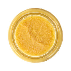 Opened jar of ginger paste on a white background