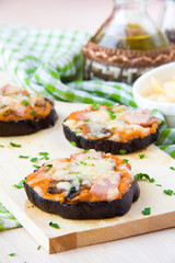 Slice of fried aubergines with tomato, mushrooms, ham and cheese