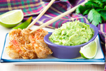 Fried shrimp in breadcrumbs and green sauce, guacamole with avoc