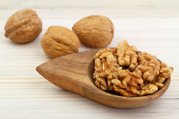 Walnuts with and without shell on wooden background