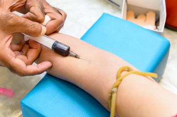 Fototapeta premium The doctor used syringe is taking blood for test