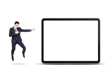 Businessman jumps and pointing digital tablet