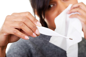 Young sick woman checking her temperature