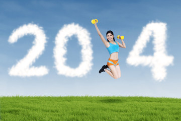 Fitness young woman jumping with new year 2014