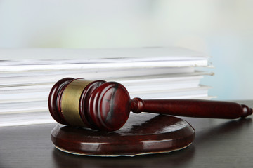 Gavel and documents on table on light background