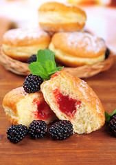 Tasty donuts with berries on wooden table