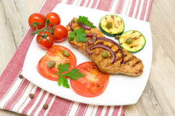 Grilled meat with vegetables on a plate. horizontal photo.