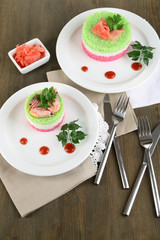 Colored rice on plates on napkins on wooden table