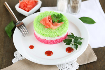 Colored rice on plate on napkins on wooden table