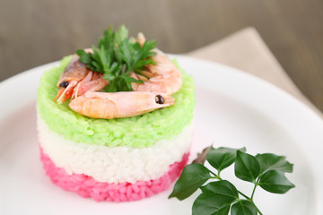 Colored rice on plate on napkin on wooden table