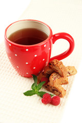 Cup of tea with cookies and raspberries isolated on white