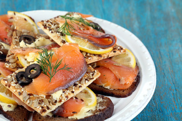 Salmon sandwiches on plate  on wooden table close-up