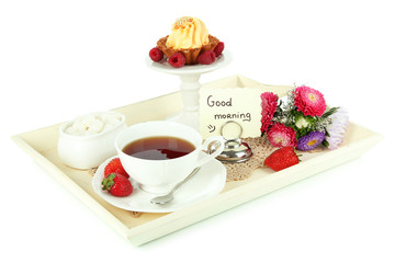 Cup of tea with cakes on wooden tray isolated on white